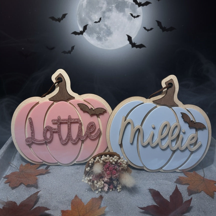 Two pumpkin-shaped tags with names 'Lottie' and 'Millie' against a Halloween-themed background with a full moon and bats.