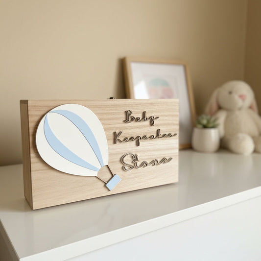 Wooden box with hot air balloon design and 'Baby Keepsake Box' text on a shelf.
