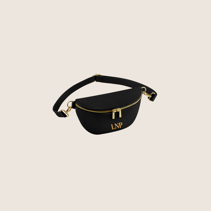 personalised Black waist bag with gold accents and 'LNP' monogram on a beige background