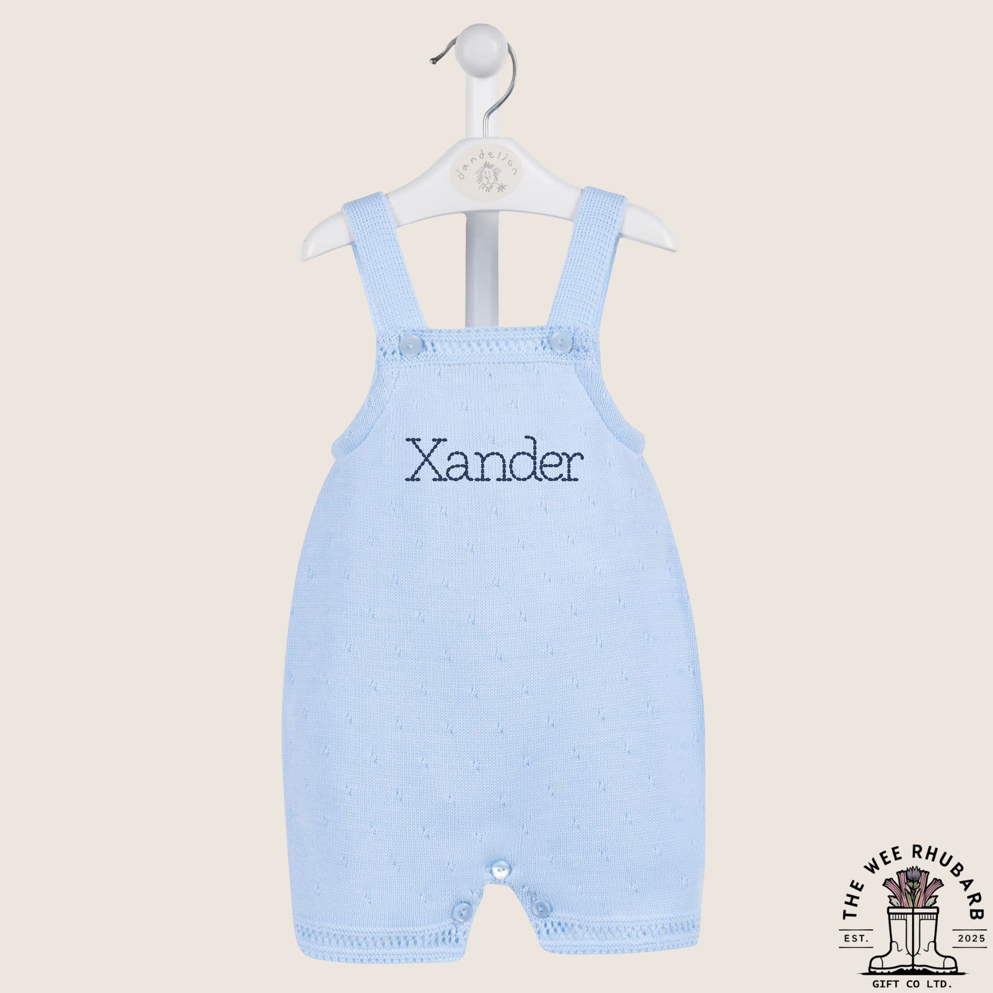 The Wee Rhubarb Gift Co Ltd pastel blue knitted baby romper with 'Xander' embroidered on the chest. Button fastenings.