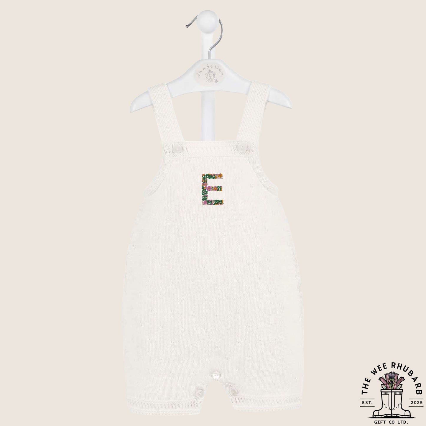 The Wee Rhubarb Gift Co Ltd white knitted baby romper with embroidered floral letter E on the chest. Button closure.