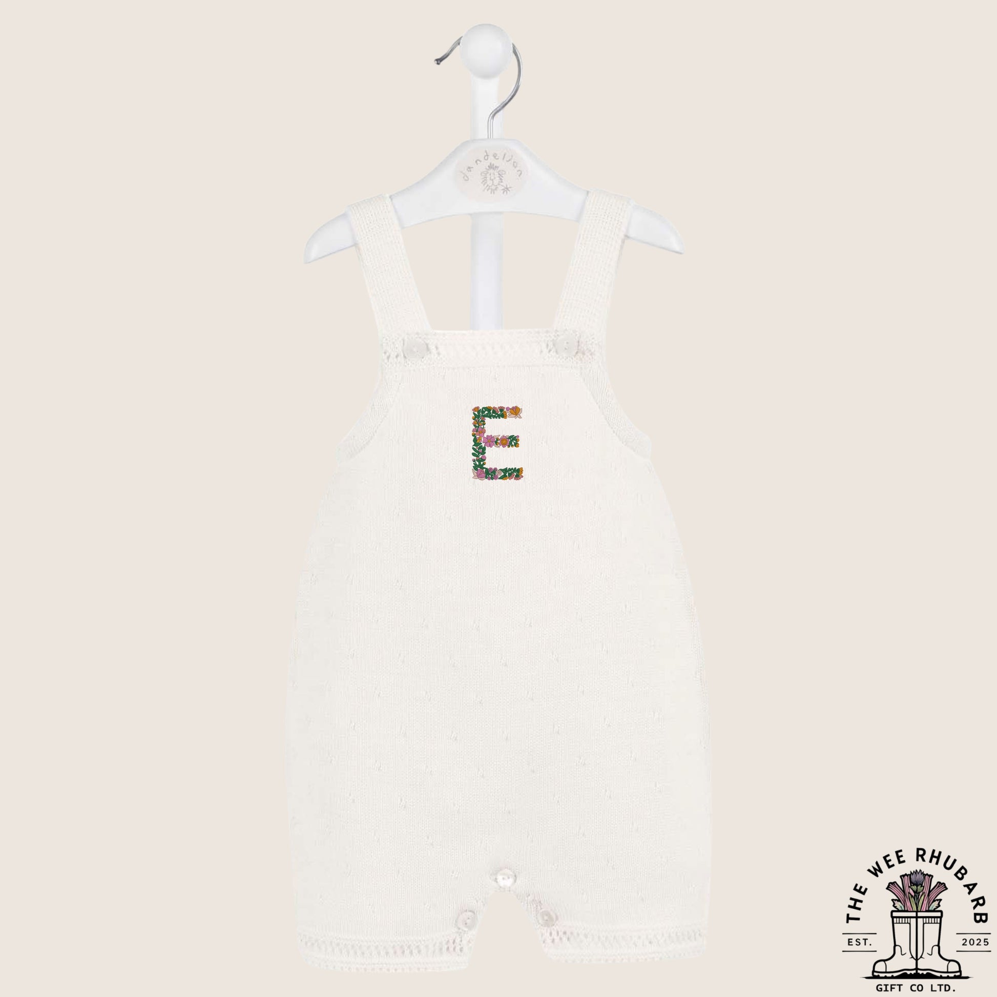 The Wee Rhubarb Gift Co Ltd white knitted baby romper with embroidered floral letter E on the chest. Button closure.