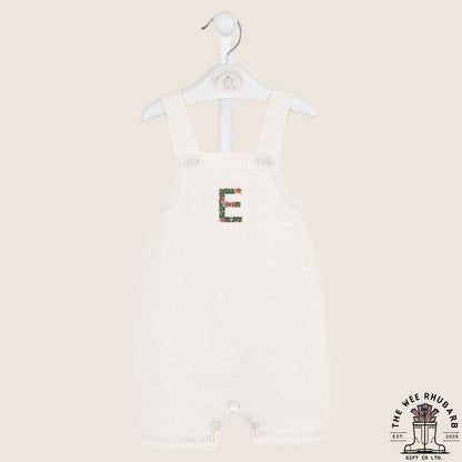 The Wee Rhubarb Gift Co Ltd white knitted baby romper with embroidered floral letter E on the chest. Button closure.
